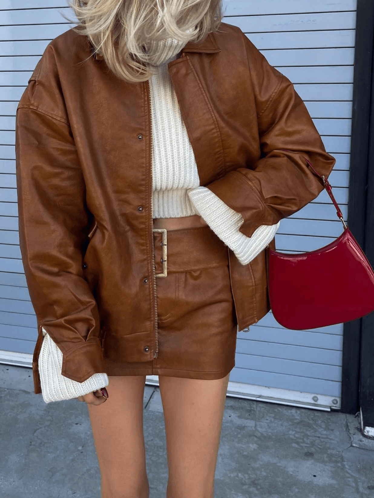 We continue to admire the beautiful and light out-of-season images of Elsa Hosk 🔥 The model is wearing a chic caramel set from the Lioness brand, consisting of a bomber jacket and a skirt. And how beautifully red accents in the form of a Prada bag, loafers, and socks go with it!