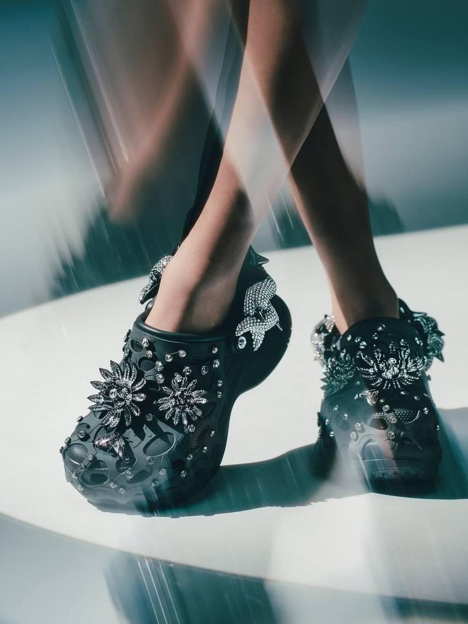 Have you seen the most unexpected collaboration of the season?
Crocs and Swarovski have teamed up to launch a limited-edition footwear collection, featuring luxurious Jibbitz and dazzling crystal embellishments that will outshine any accessory in your look!
What do you think about this bold style statement — the striking contrast between iconic “ugly shoes” and glamorous jewelry?