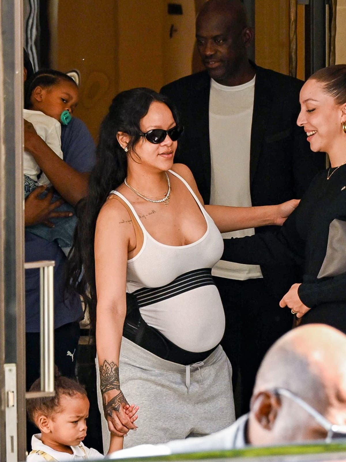 Rihanna elevates the supportive maternity belt into high‑fashion: styled over a tank top and sweatpants in Paris, the bump becomes a statement.