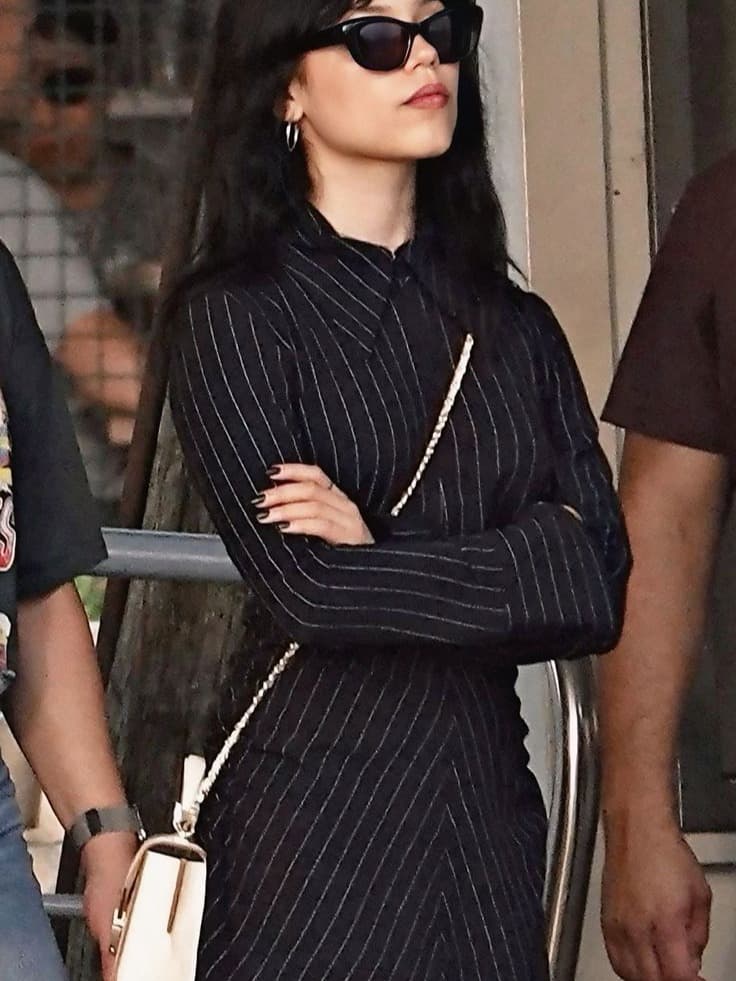 Jenna Ortega updates Dior’s classic New Look during her “Wednesday” press tour with sculpted tailoring, edgy accessories and modern goth accents.